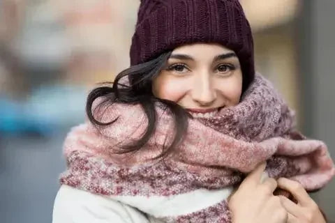 Woman wearing knitted hat and cozy pink scarf