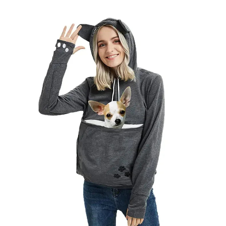 Woman wearing gray pet carrier hoodie with small dog